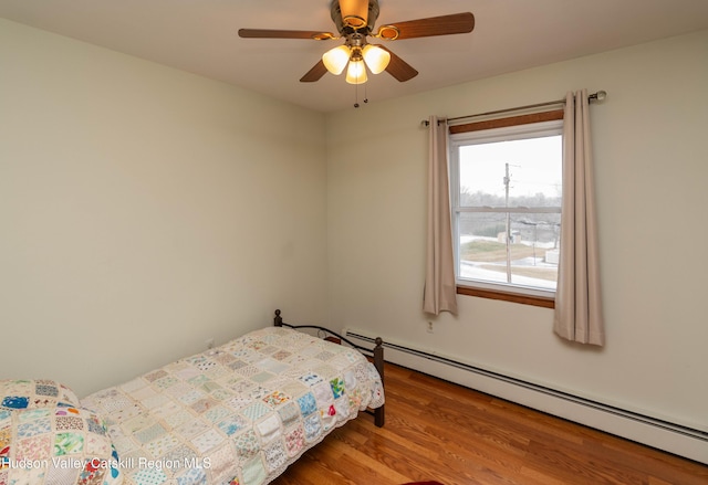 bedroom with baseboard heating, ceiling fan, and hardwood / wood-style floors