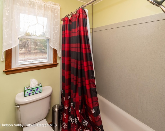 bathroom featuring toilet and shower / tub combo with curtain