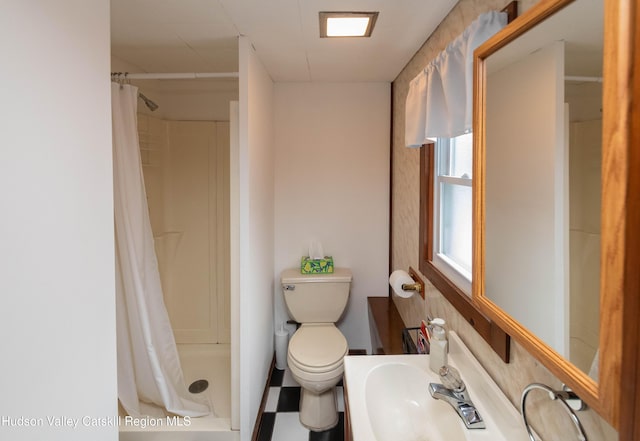 bathroom featuring curtained shower, sink, and toilet