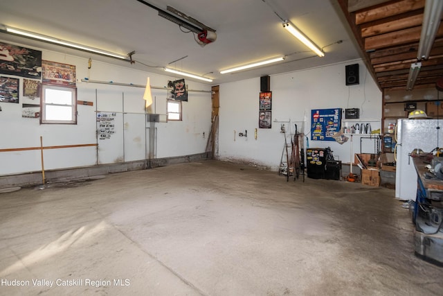 garage with white fridge and a garage door opener