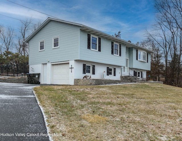 bi-level home featuring a garage and a front lawn