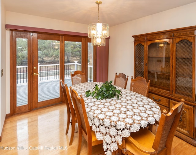 dining space featuring light wood-type flooring and a notable chandelier