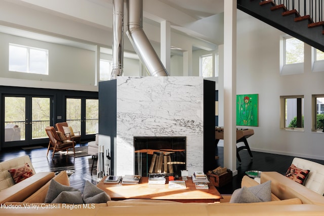 46 Pompeys Cave Rd, High Falls, NY 12440 - living room featuring a towering ceiling, french doors, a high end fireplace, healthy amount of natural light, and wood finished floors
