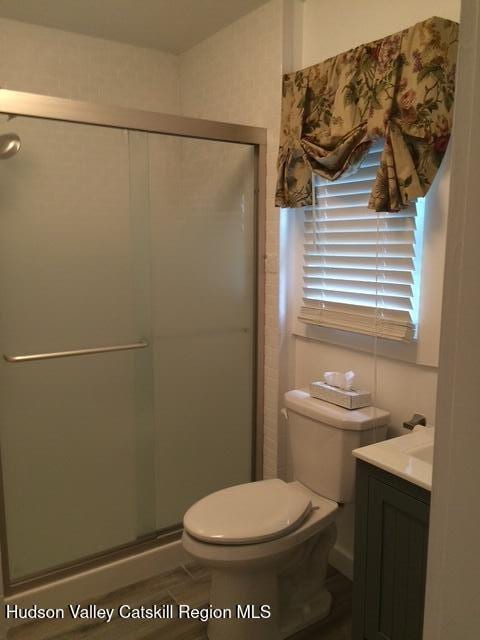 full bath featuring a shower stall, toilet, and vanity