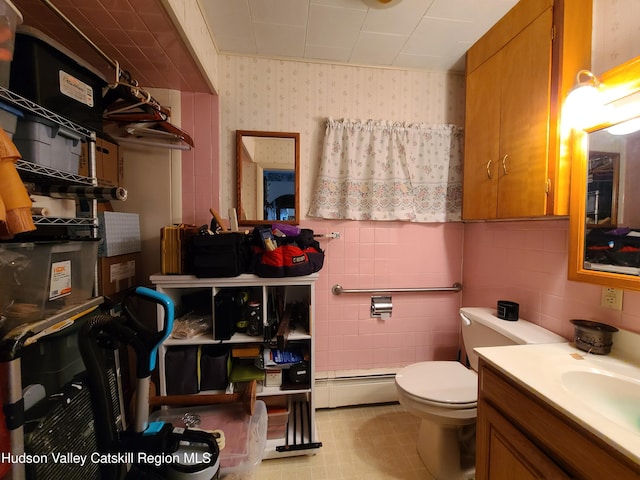 bathroom featuring vanity, tile walls, toilet, wallpapered walls, and a baseboard radiator