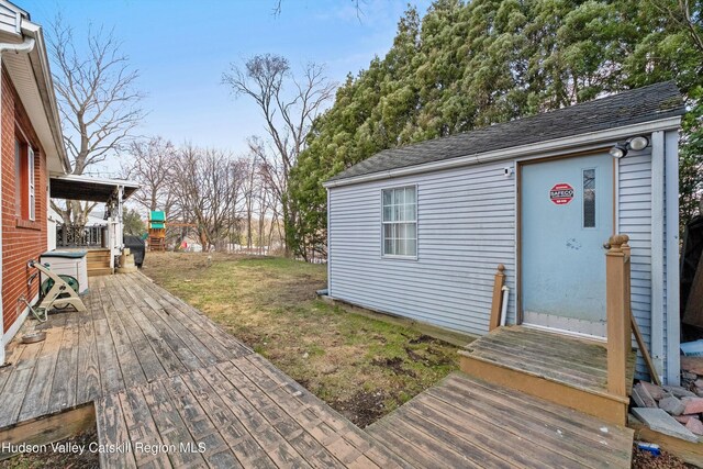 wooden terrace with a lawn and an outdoor structure