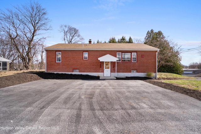 exterior space with brick siding and a chimney