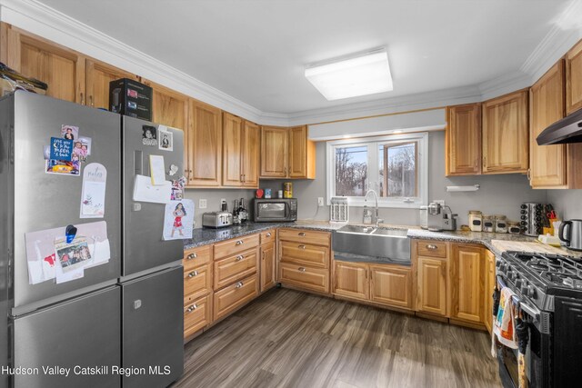 kitchen with dark wood finished floors, a sink, black microwave, gas range, and freestanding refrigerator