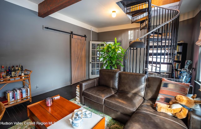 living room featuring beamed ceiling, wood-type flooring, and a barn door