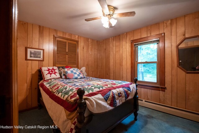 623 Rte 9j, Stuyvesant, NY 12173 - bedroom featuring a baseboard radiator, carpet, wood walls, and a ceiling fan