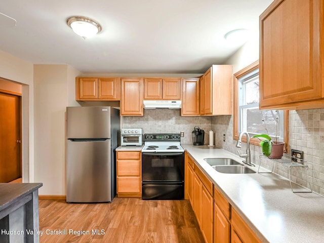 kitchen with sink, light hardwood / wood-style flooring, black electric range, decorative backsplash, and stainless steel fridge