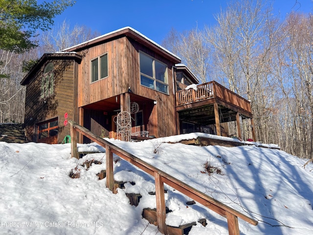 snow covered property featuring a deck