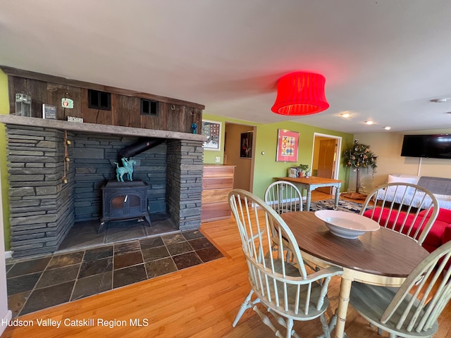 dining room with dark hardwood / wood-style flooring and a wood stove