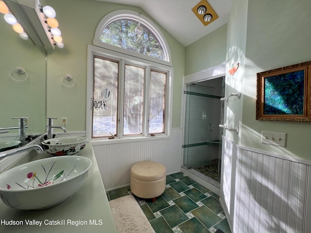 bathroom featuring a textured ceiling, vanity, a shower with shower door, and lofted ceiling