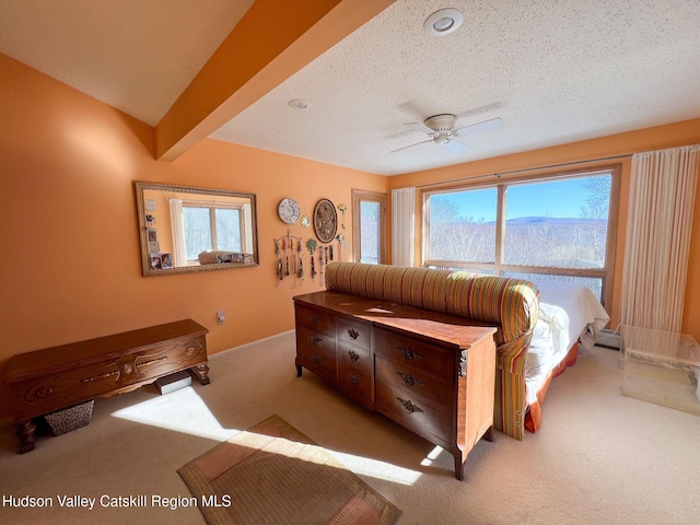 carpeted bedroom featuring beamed ceiling, a textured ceiling, and ceiling fan