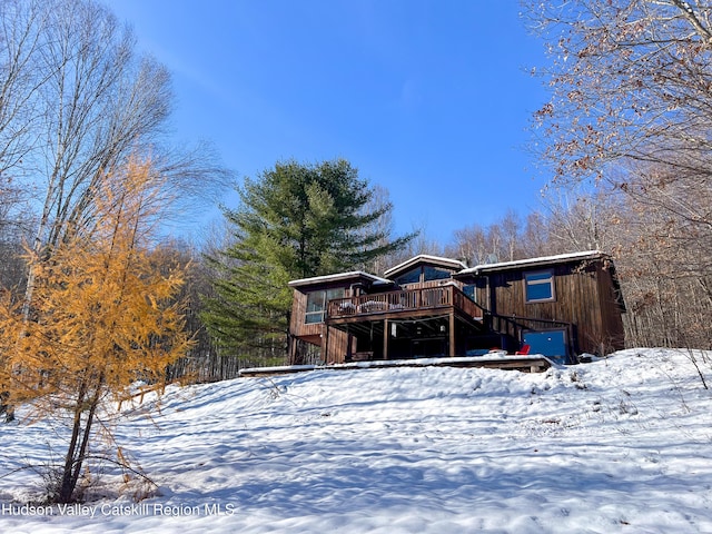 snow covered house featuring a deck