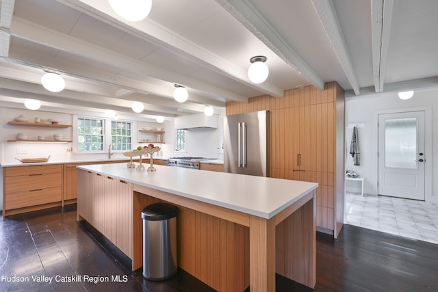 kitchen featuring beam ceiling, a kitchen island, dark hardwood / wood-style floors, and appliances with stainless steel finishes