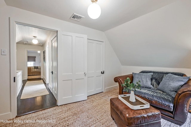 sitting room with light colored carpet and vaulted ceiling