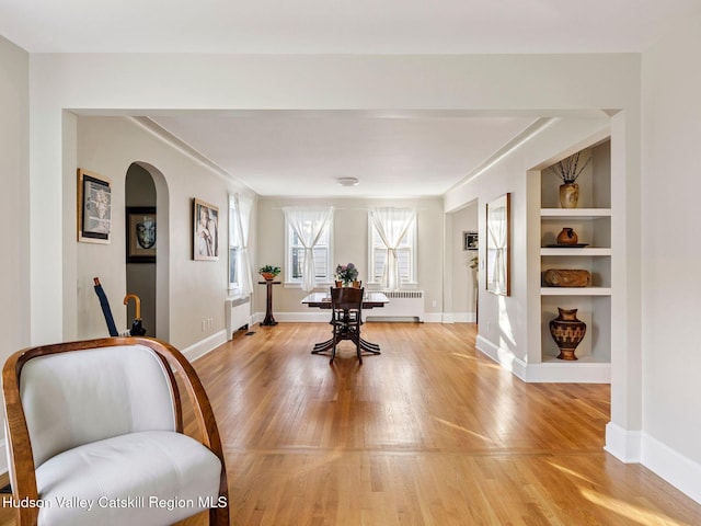 90 Emerson St, Kingston, NY 12401 - exercise area featuring light wood-style floors, radiator heating unit, and arched walkways