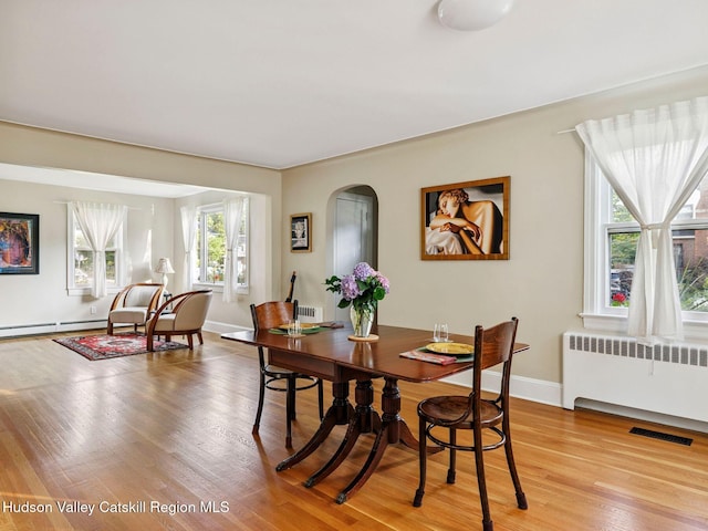 90 Emerson St, Kingston, NY 12401 - dining area featuring radiator, light wood-style floors, and arched walkways