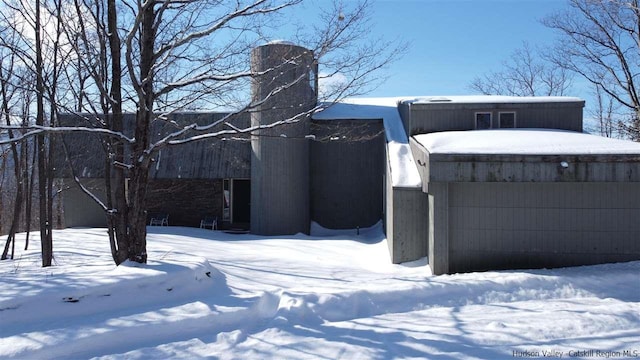 snow covered property with a garage