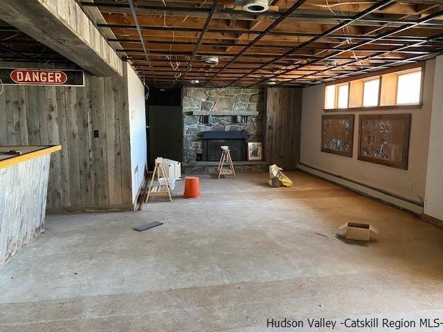 basement featuring a fireplace and a baseboard heating unit