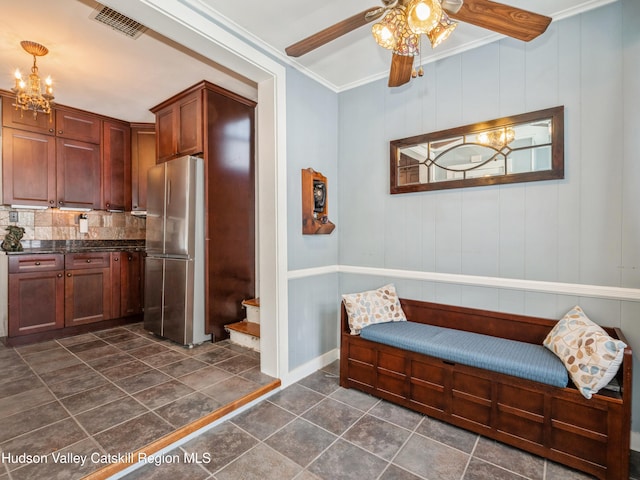 interior space with stainless steel fridge, ceiling fan with notable chandelier, and crown molding