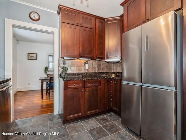 kitchen with backsplash, appliances with stainless steel finishes, and dark stone counters