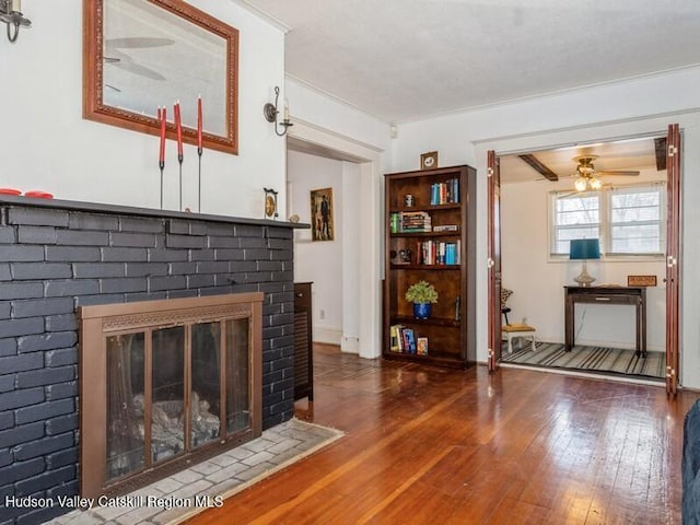 unfurnished living room featuring ceiling fan, a fireplace, and dark hardwood / wood-style flooring