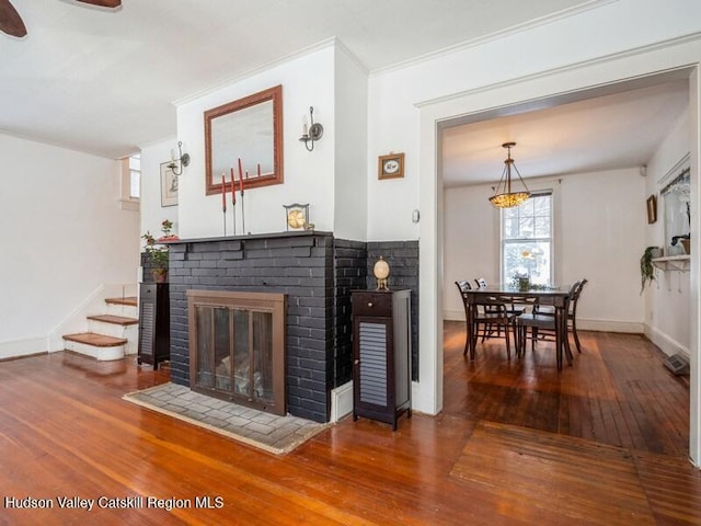 living room with a fireplace, ornamental molding, and hardwood / wood-style floors