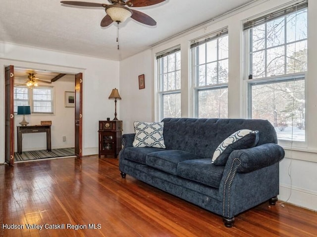 living room featuring ceiling fan, dark hardwood / wood-style floors, and ornamental molding