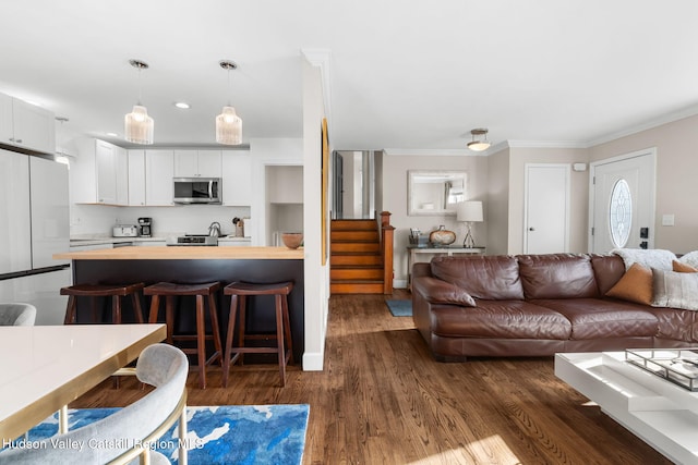 living room featuring ornamental molding and dark wood-type flooring