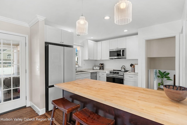 kitchen with white cabinets, dark wood-type flooring, and appliances with stainless steel finishes