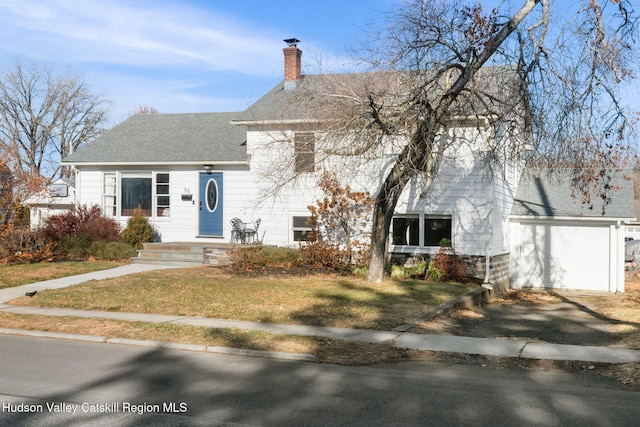 view of front of home featuring a front yard, an outbuilding, and a garage