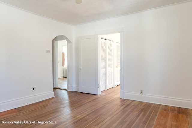 empty room featuring hardwood / wood-style flooring and radiator