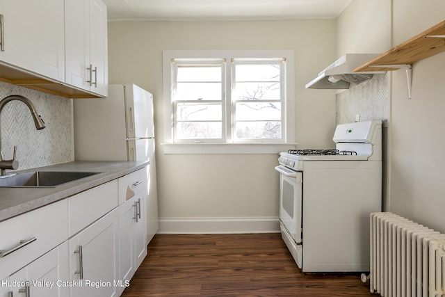 kitchen with sink, white gas stove, white cabinetry, radiator, and decorative backsplash