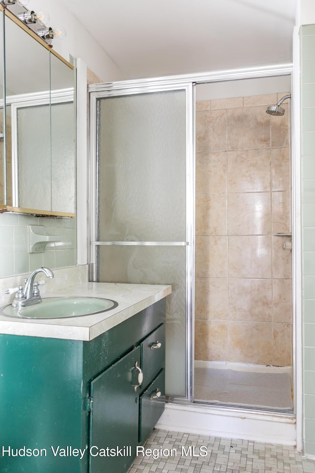 bathroom with a shower with door and vanity