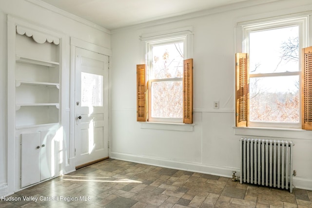 doorway with crown molding and radiator