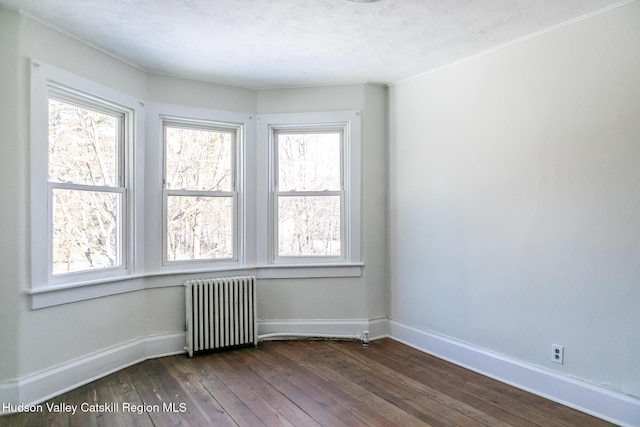 unfurnished room with radiator heating unit, dark hardwood / wood-style floors, and a textured ceiling