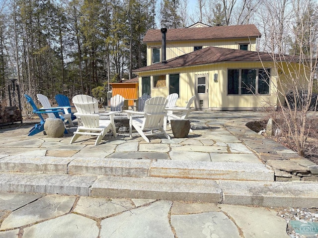  - rear view of house featuring a patio area and roof with shingles