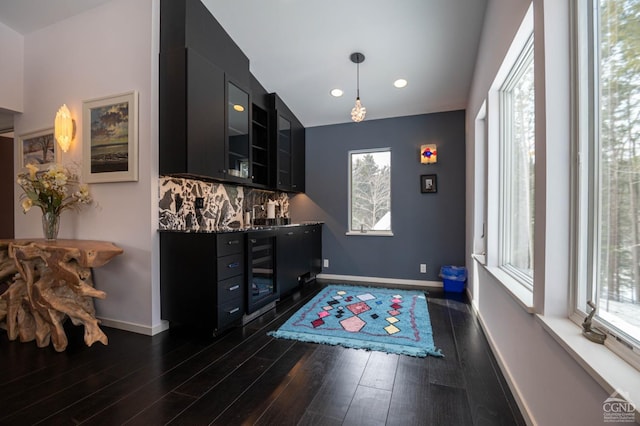  - foyer featuring beverage cooler, dark wood-type flooring, baseboards, recessed lighting, and bar area