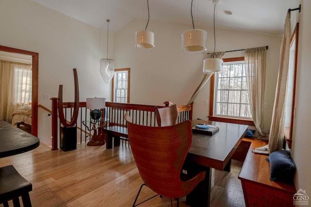  - dining space featuring vaulted ceiling and wood finished floors