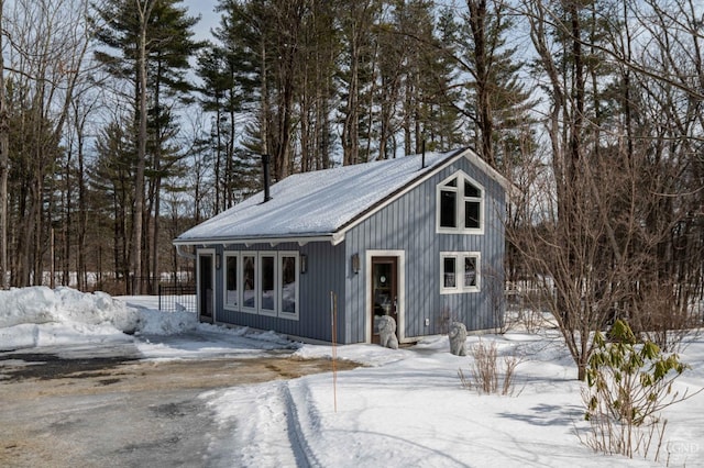  - snow covered structure with an outbuilding