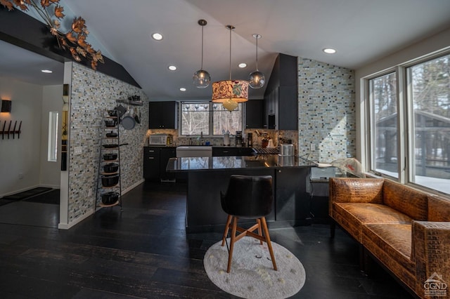  - bar featuring vaulted ceiling, hanging light fixtures, decorative backsplash, a sink, and recessed lighting