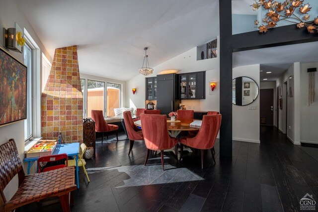  - dining space featuring lofted ceiling, dark wood finished floors, and baseboards