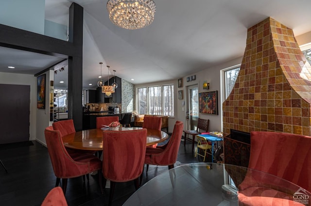  - dining area featuring a chandelier, a fireplace, and lofted ceiling