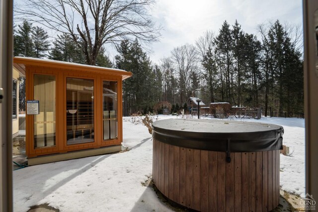  - snow covered patio featuring a hot tub