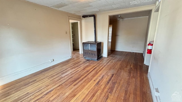 801 Columbia St, Hudson, NY 12534 - spare room featuring heating unit, wood finished floors, a wood stove, and baseboards