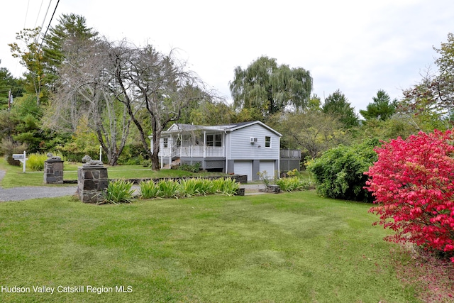 back of house featuring a lawn, a porch, and a garage