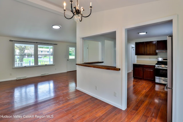 kitchen with dark brown cabinetry, dark hardwood / wood-style flooring, stainless steel stove, and a notable chandelier